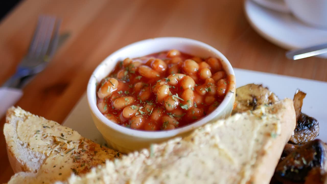 Baked beans and buttered toast with mushrooms on a breakfast plate